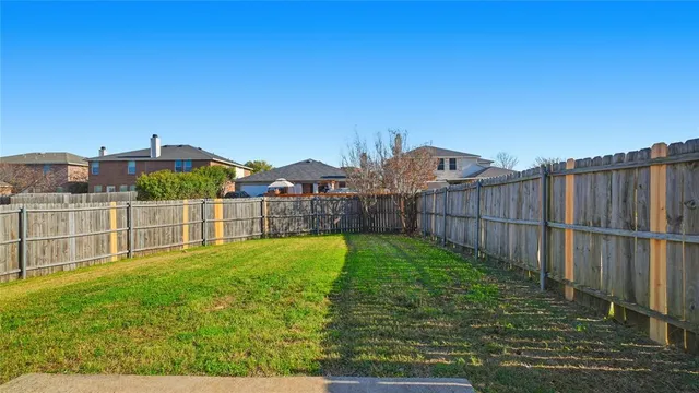 a view of a garden with a small yard and wooden fence