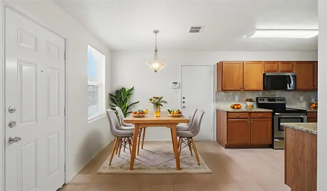 a kitchen with stainless steel appliances granite countertop a stove top oven a sink a counter space and cabinets