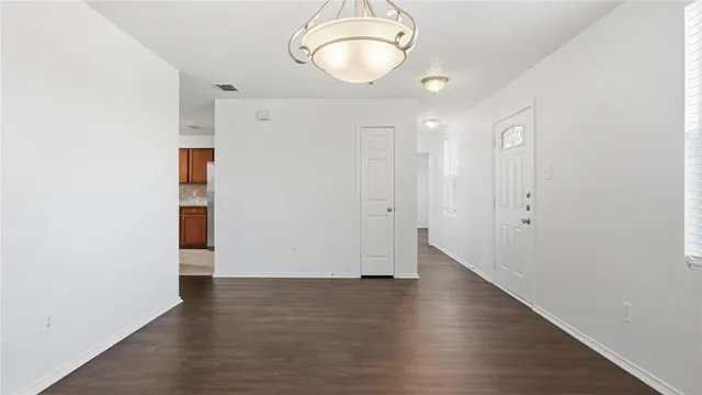 an empty room with wooden floor and mirror
