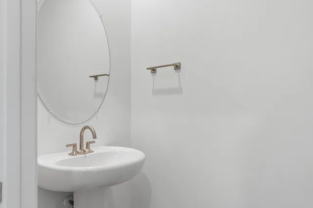 a bathroom with a granite countertop bathtub shower sink vanity and toilet