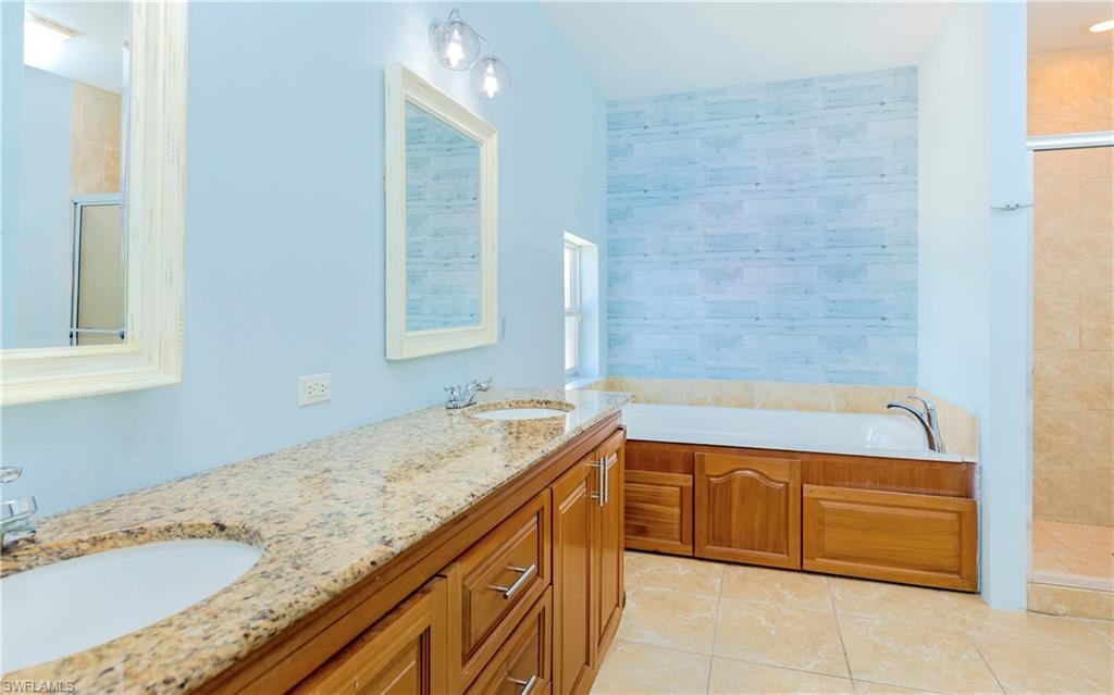12277 Boat Shell Drive Matlacha Isles, FL 33991 - Photo 19 of 46 a bathroom with a granite countertop bathtub sink and mirror