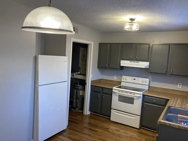 a kitchen with a refrigerator and a stove top oven
