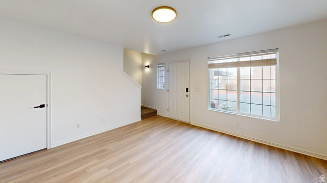 1115 North Main Street Bountiful, UT 84010 - Photo 14 of 17 Bright living area featuring wood-finish flooring, white walls, and a large window with white muntins