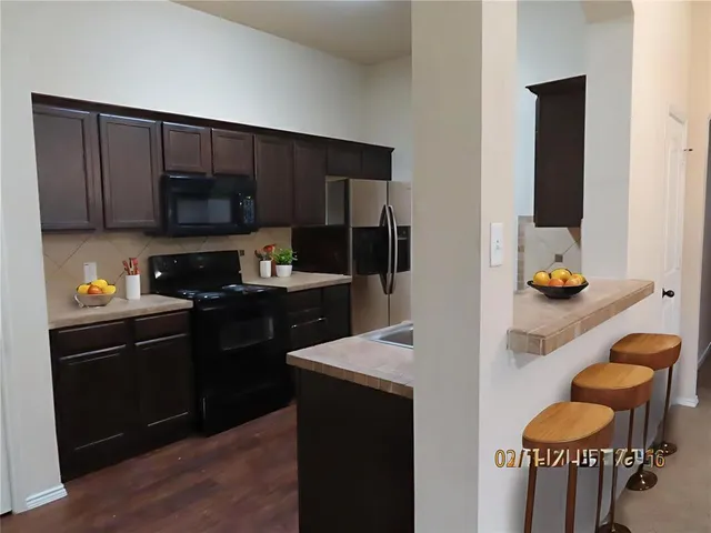 a kitchen with granite countertop stainless steel appliances and wooden cabinets