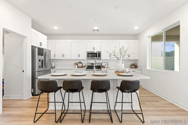 a open dining room with stainless steel appliances kitchen island granite countertop a table and chairs in it