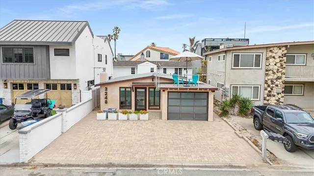 a view of a white building with a tub and a barbeque grill