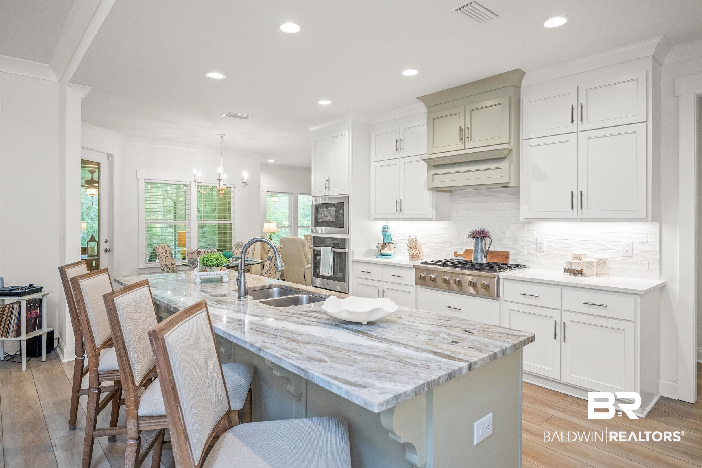 4601 Surrey Lane Orange Beach, AL 36561 - Photo 12 of 43 Kitchen featuring a kitchen island with sink, light hardwood / wood-style floors, stainless steel appliances, and hanging light fixtures