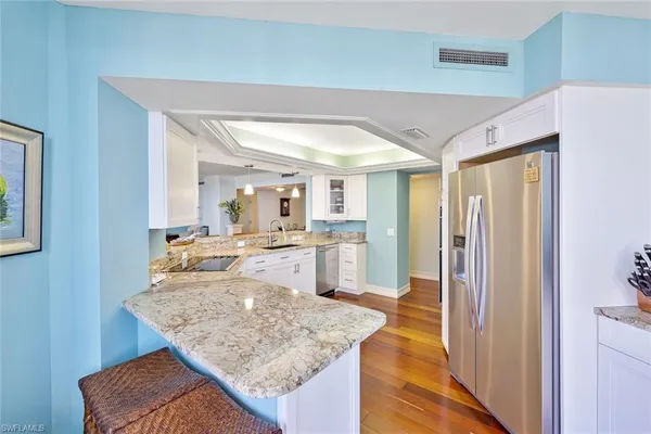a large kitchen with a lot of counter space and wooden floor