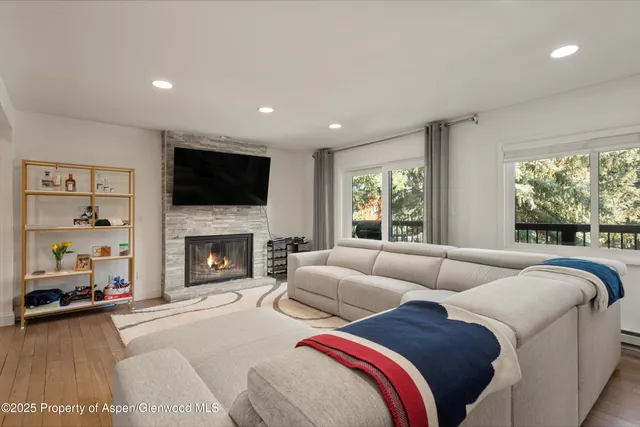 a living room with furniture large window and a fireplace