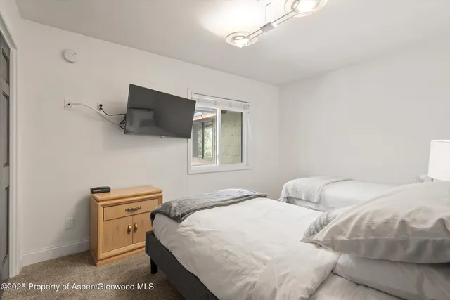 a bedroom with a bed and a flat screen tv