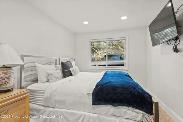 a bed sitting in a bedroom next to a window