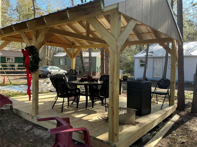 a view of a patio with table and chairs potted plants and floor to ceiling window