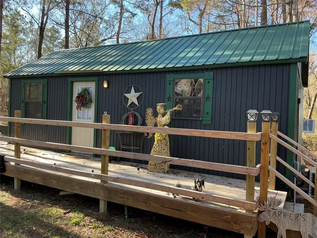 a view of two chairs and table in the balcony next to a house