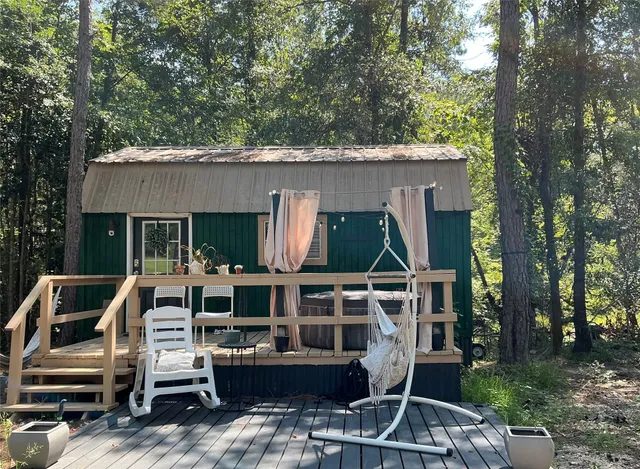 a view of backyard with deck and outdoor seating