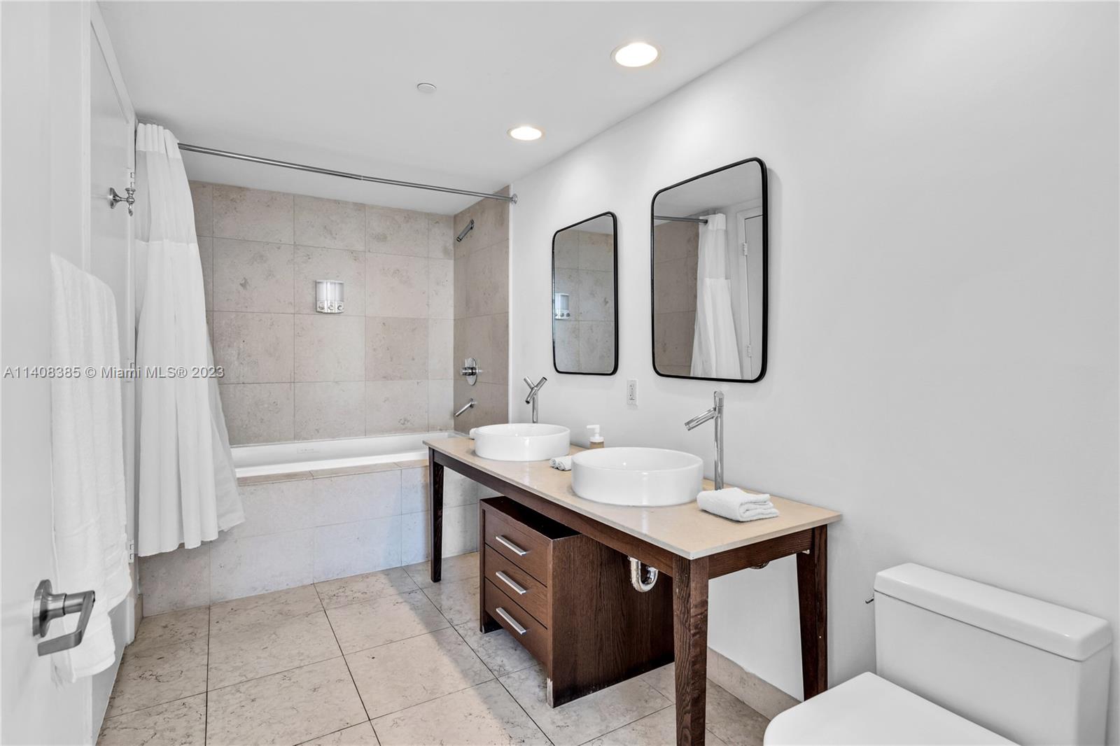 Brickell Miami, FL 33131 - Photo 11 of 25 a bathroom with a tub sink and mirror