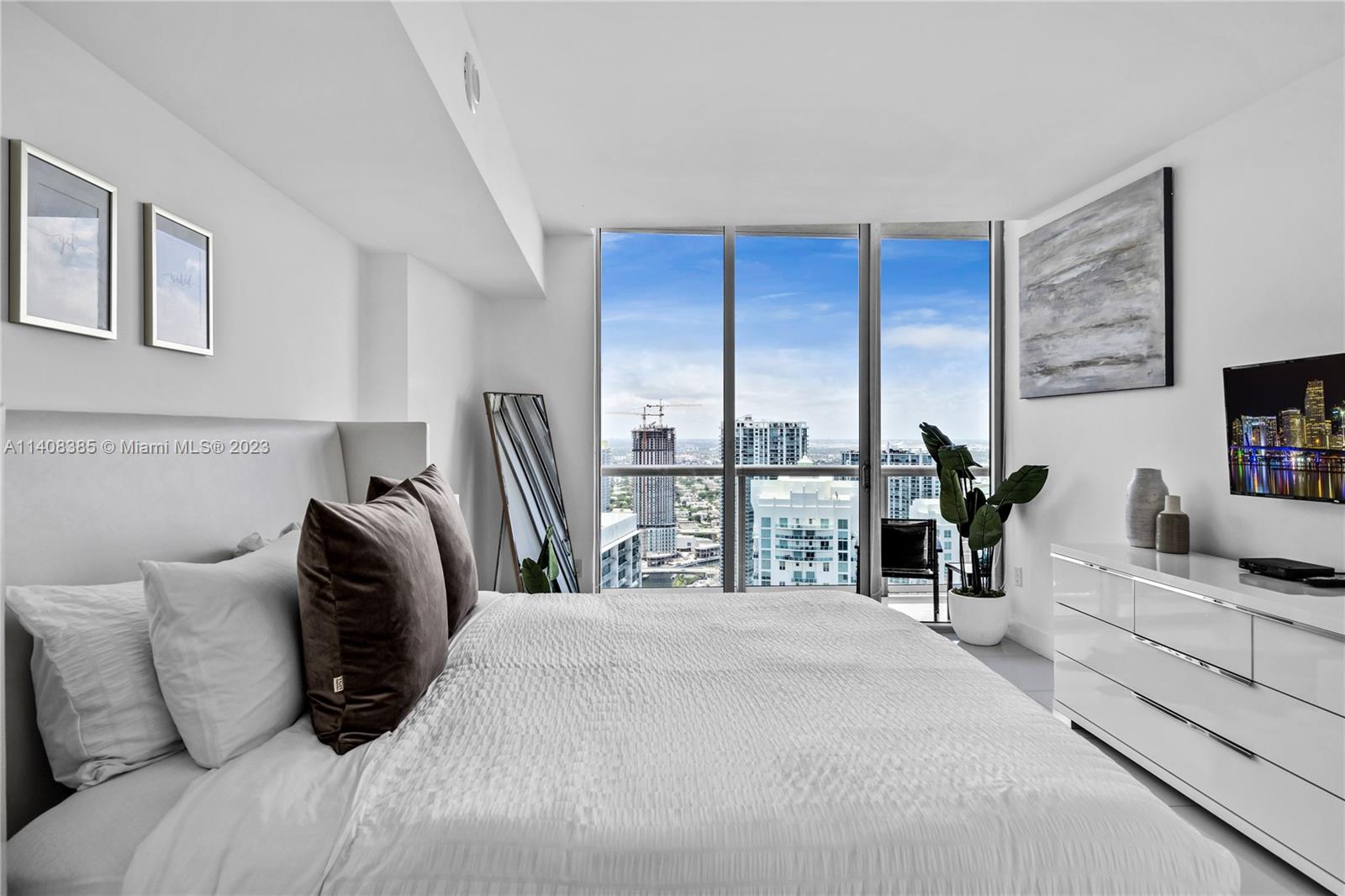 Brickell Miami, FL 33131 - Photo 13 of 25 a bedroom with a bed a couch and large window