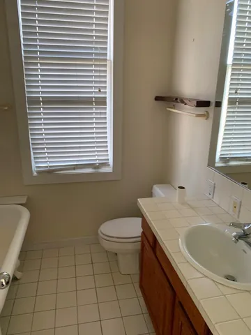 a bathroom with a sink toilet and window