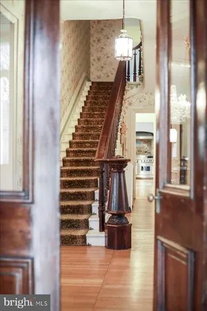 a view of staircase with lots of frames on wall and a window