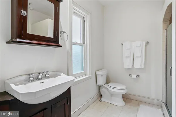 a bathroom with a sink a toilet and mirror