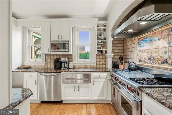a kitchen with stainless steel appliances granite countertop a stove a sink and a refrigerator