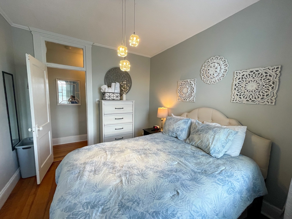 31 Orkney Road, Unit 46 Boston, MA 02135 - Photo 6 of 7 a bedroom with a bed and a chandelier
