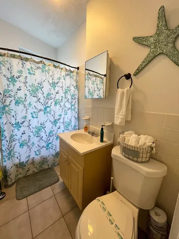a bathroom with a granite countertop toilet sink and mirror
