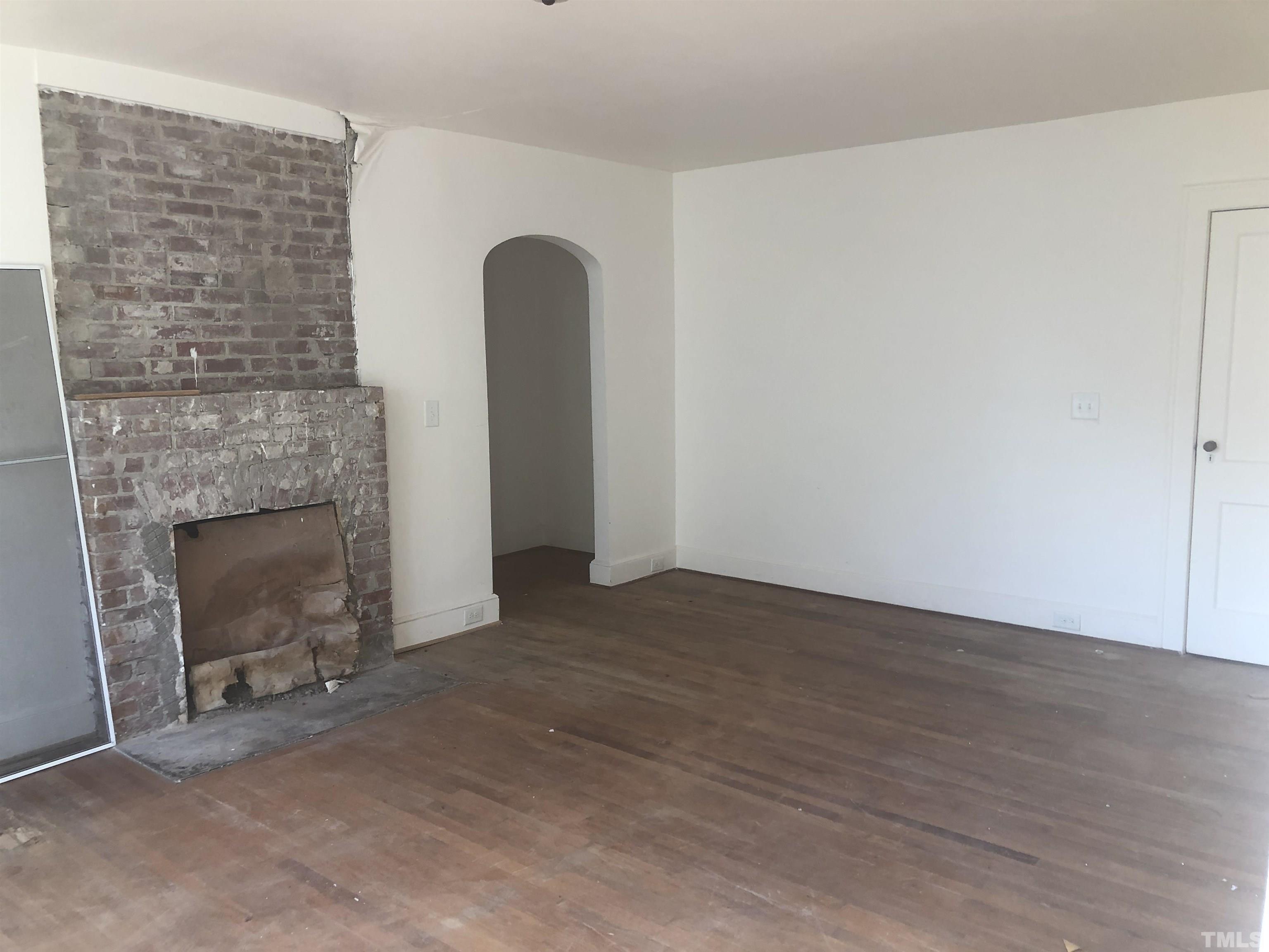 104 Dixie Trail Raleigh, NC 27607 - Photo 6 of 19 a view of an empty room with wooden floor and a fireplace