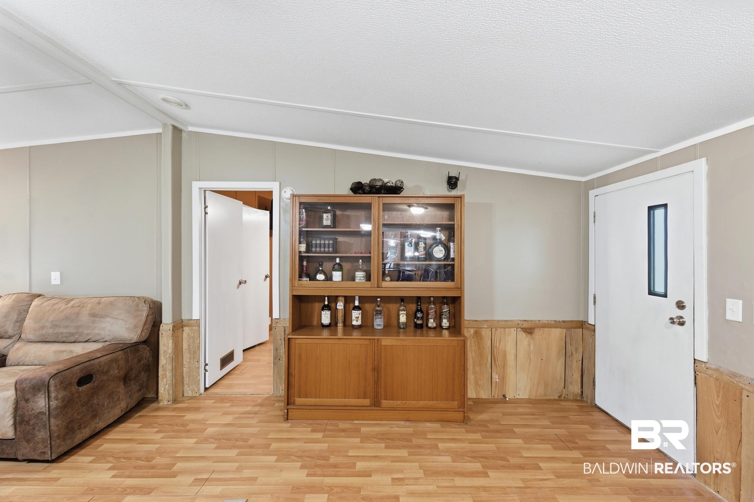 926 Tumbling Lane Atmore, AL 36502 - Photo 13 of 56 Light wood-finish flooring complements the light gray walls and wood paneling