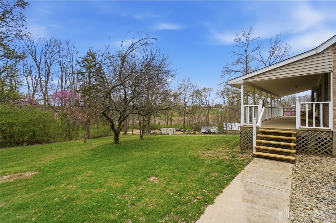 7553 Coffin Station Road Springfield, OH 45502 - Photo 83 of 95 This inviting outdoor space features a well-maintained lawn and a welcoming covered porch.