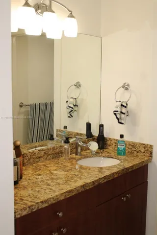 a bathroom with a granite countertop sink and a mirror