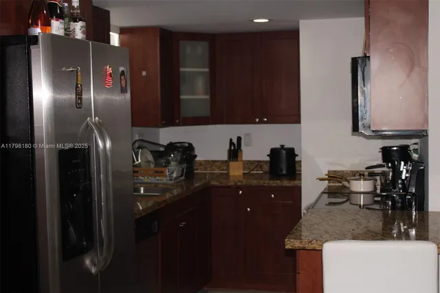 a kitchen with stainless steel appliances granite countertop a refrigerator a sink and a stove