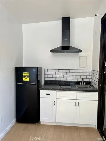 a kitchen with granite countertop white cabinets and stainless steel appliances