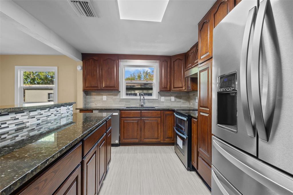 1908 West Fern Street Tampa, FL 33604 - Photo 8 of 47 a kitchen with stainless steel appliances granite countertop a refrigerator a stove top oven and a sink