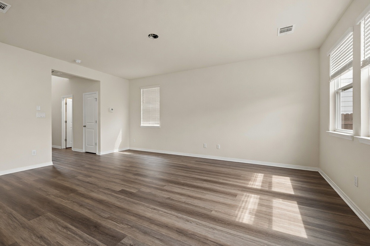 129 Greenway Drive Georgetown, TX 78628 - Photo 5 of 22 a view of an empty room with wooden floor and windows