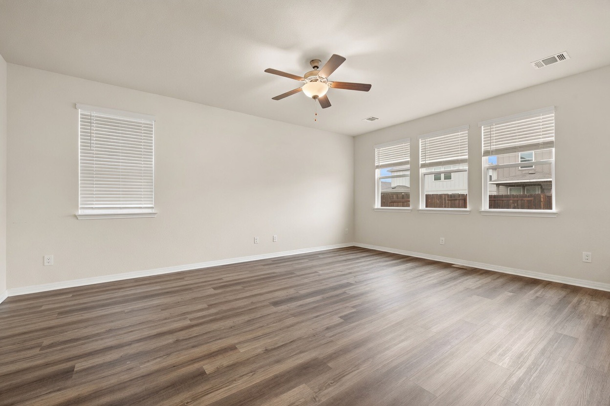 129 Greenway Drive Georgetown, TX 78628 - Photo 6 of 22 a view of an empty room with wooden floor and a window