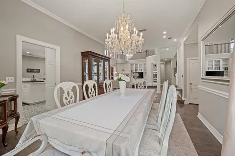 a large white kitchen with chandelier and stainless steel appliances