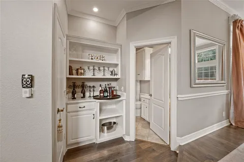 a kitchen with white cabinets and window