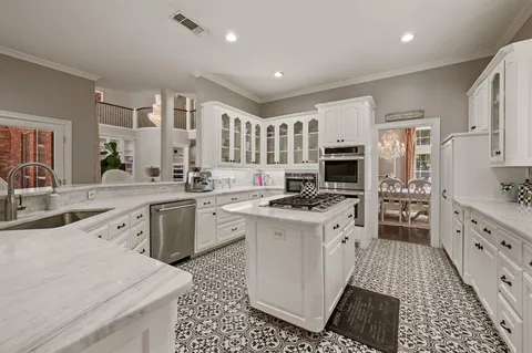 a large kitchen with stainless steel appliances granite countertop a stove and a sink
