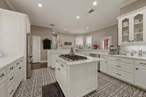 a kitchen with granite countertop appliances a sink and a refrigerator