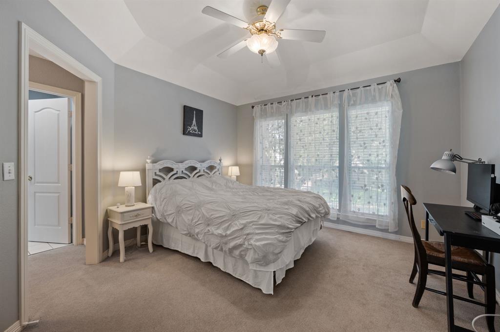 2906 Edgewood Lane Colleyville, TX 76034 - Photo 34 of 40 a spacious bedroom with a bed and a table in it