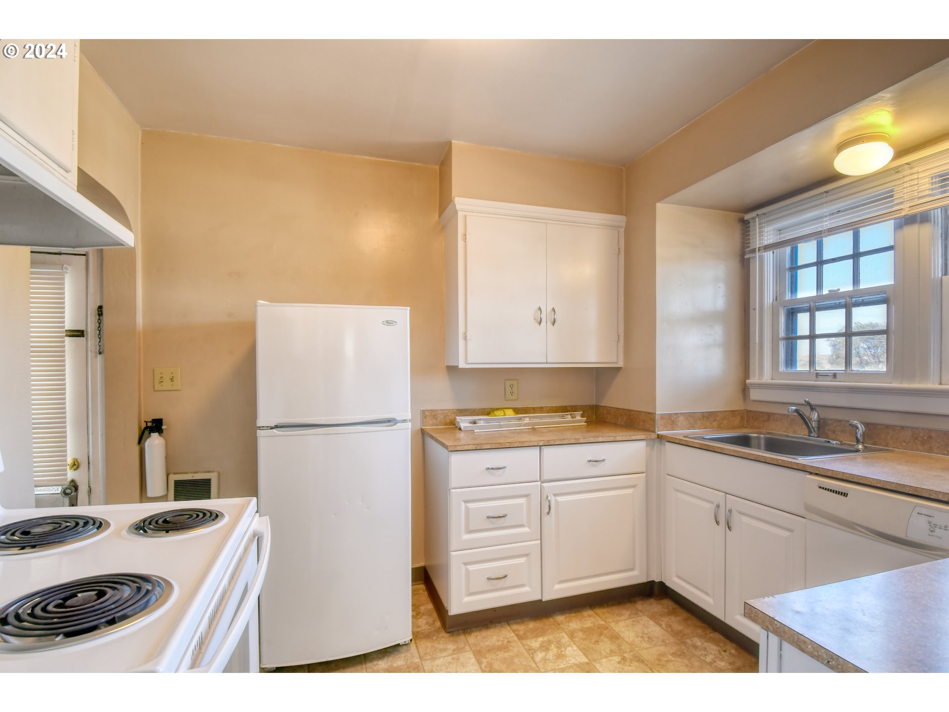 1016 Southwest Goodwin Place Pendleton, OR 97801 - Photo 11 of 36 a kitchen with a white stove a sink and a refrigerator