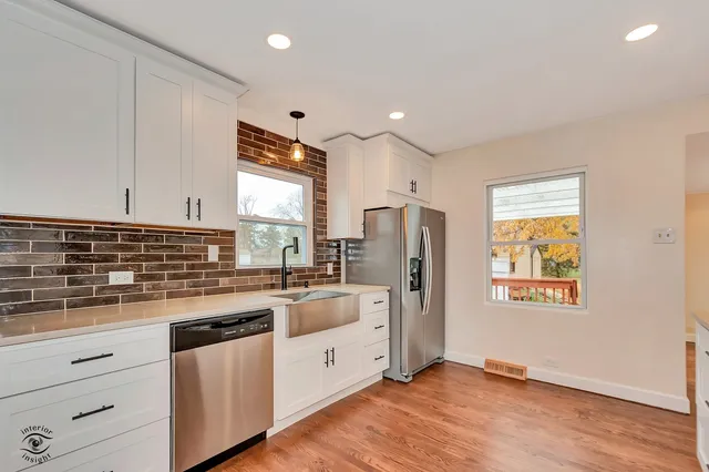 a kitchen with refrigerator cabinets and wooden floor