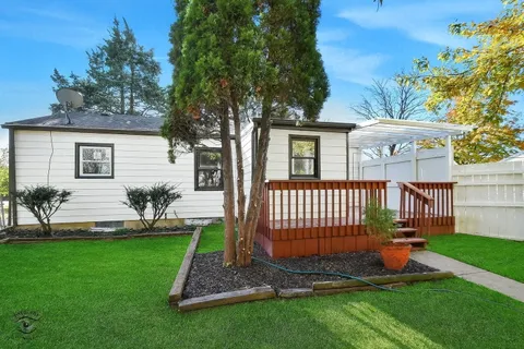 a view of a house with a small yard and wooden fence