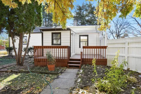 a view of a tree in front of a house with a big yard