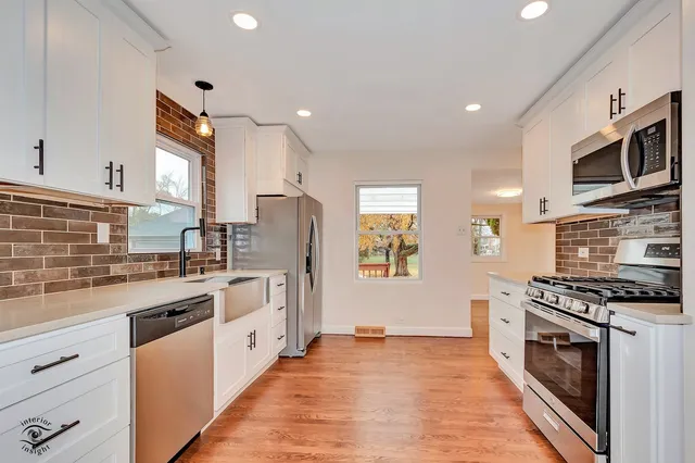 a kitchen with stainless steel appliances a stove sink microwave and cabinets