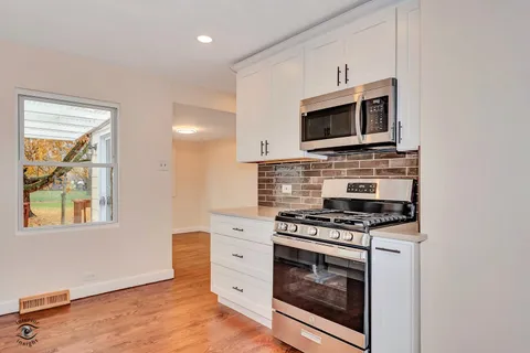 a kitchen with stainless steel appliances a stove microwave and sink