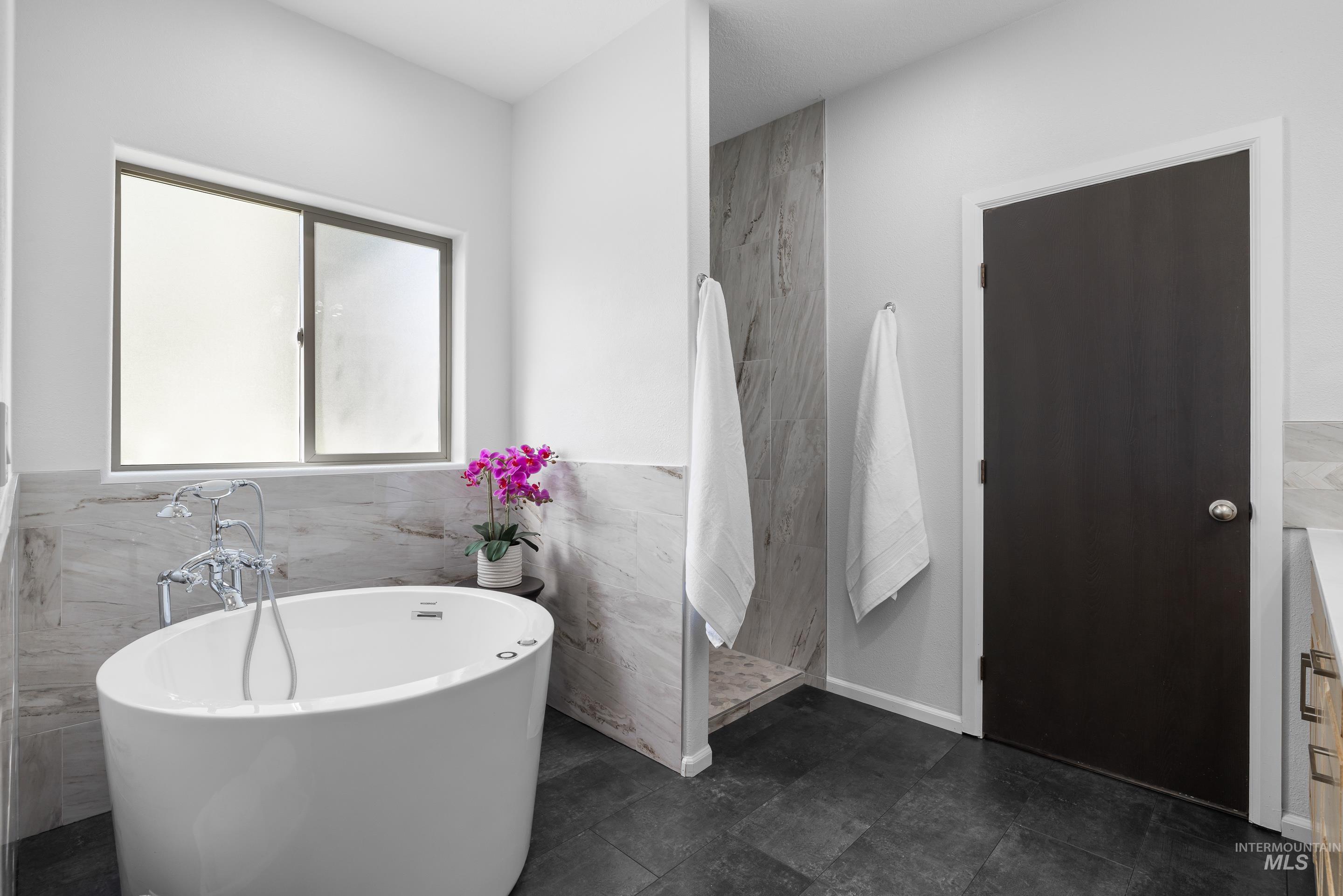 14119 Silver Ridge Road Caldwell, ID 83607 - Photo 23 of 50 Full bathroom with a soaking tub, tile walls, and a walk in shower