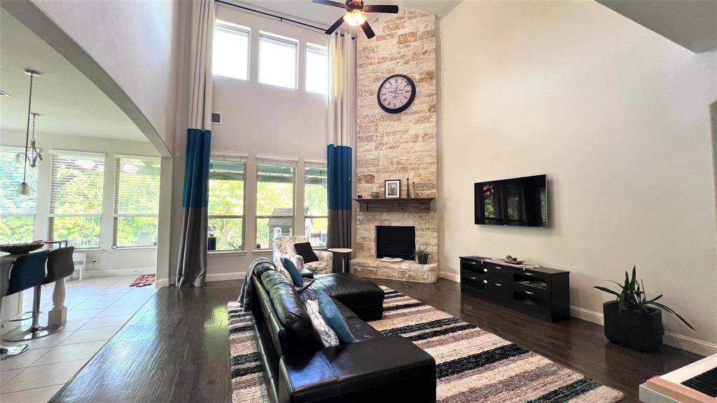 a living room with furniture a flat screen tv and a floor to ceiling window