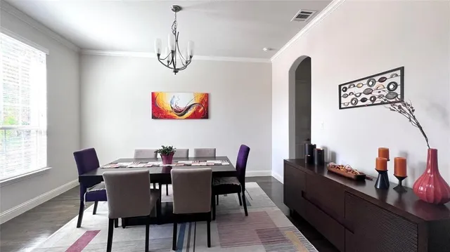 a view of a dining room with furniture a chandelier and wooden floor