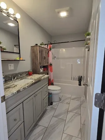 a bathroom with a sink a toilet and shower